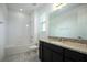 Bathroom featuring a tub, granite counter top, dark cabinets, tiled floors, and a well lit mirror at 16695 Broadwater Ave, Winter Garden, FL 34787