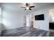 Bedroom with wood flooring, ceiling fan, TV, and a closet, flowing into the bathroom space at 16695 Broadwater Ave, Winter Garden, FL 34787