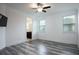 Bright bedroom with gray wood flooring, ceiling fan, and a view into the bathroom at 16695 Broadwater Ave, Winter Garden, FL 34787