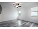 Spacious bedroom featuring gray wood flooring, a modern ceiling fan, and bright, natural light from two windows at 16695 Broadwater Ave, Winter Garden, FL 34787