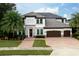 Elegant two-story home with a tiled roof, three-car garage, landscaped front yard, and paver driveway at 16695 Broadwater Ave, Winter Garden, FL 34787