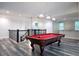 Spacious game room featuring a classic pool table under pendant lighting with stairs and a bar in the background at 16695 Broadwater Ave, Winter Garden, FL 34787