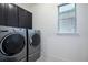 Laundry room with window and stainless-steel washer and dryer at 16695 Broadwater Ave, Winter Garden, FL 34787