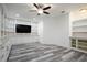 The spacious living room boasts built-in shelving and cabinets, modern lighting, and stylish wood flooring at 16695 Broadwater Ave, Winter Garden, FL 34787