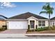 One-story home with white garage door, gray front door, and landscaped yard at 258 Vizcay Way, Davenport, FL 33837