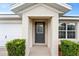 Gray front door with glass accents and a covered entryway at 258 Vizcay Way, Davenport, FL 33837