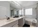 Bathroom with double vanity, marble countertop, and a glass shower plus a soaking tub at 2691 Hawthorne Ln, Kissimmee, FL 34743