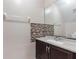 Bathroom features a granite countertop, dark cabinets, and tiled backsplash at 2691 Hawthorne Ln, Kissimmee, FL 34743