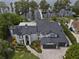 Aerial view displays a luxury home with a dark roof, a three-car garage, and lush landscaping at 904 Main St, Windermere, FL 34786