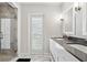 This bathroom features a marble-accented glass shower, double vanity, and plantation shutters at 904 Main St, Windermere, FL 34786