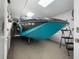 A well-lit boat garage featuring a sleek black and turquoise boat, stored indoors for protection and convenience at 904 Main St, Windermere, FL 34786