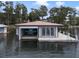 Floating boathouse with a covered boat slip and adjacent dock on a serene lake at 904 Main St, Windermere, FL 34786