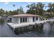 Modern floating boathouse with a white exterior, metal roof, and a wooden dock at 904 Main St, Windermere, FL 34786