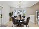 Dining area with modern chandelier and views of tropical greenery and water at 904 Main St, Windermere, FL 34786