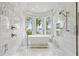 Luxurious bathroom with marble finishes, a modern tub, and backyard views at 904 Main St, Windermere, FL 34786