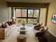 Sunlit living room with large window, plush seating, and dark wood-look floors at 588 Orange Dr # 131, Altamonte Springs, FL 32701