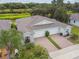 A villa showcasing a two-car garage with a brick driveway and a lush green landscape at 1862 Overcup Ave, Saint Cloud, FL 34771