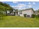 Exterior view of home featuring lush lawn, landscaping, and screened-in porch at 1862 Overcup Ave, Saint Cloud, FL 34771