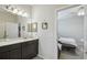 Well-lit bathroom featuring dark cabinets, neutral countertops, and a view to the bedroom at 1862 Overcup Ave, Saint Cloud, FL 34771