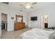 Primary bedroom boasts an ensuite bath, dresser, ceiling fan, and mounted TV at 1862 Overcup Ave, Saint Cloud, FL 34771