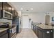 Well-lit kitchen equipped with stainless steel appliances and a granite countertop island with sink at 1862 Overcup Ave, Saint Cloud, FL 34771