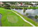 Aerial view of a home with an enclosed pool area, bordering a lake and golf course at 14126 Fox Glove St, Winter Garden, FL 34787
