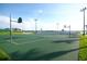 Outdoor community basketball court with multiple hoops, lights and a partial view of a lake in background at 14126 Fox Glove St, Winter Garden, FL 34787