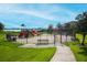 Community playground with swings and slides surrounded by a black metal fence and landscaping at 14126 Fox Glove St, Winter Garden, FL 34787