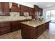 Spacious kitchen features dark cabinetry, stone tile backsplash, and a generous island with granite countertop at 14126 Fox Glove St, Winter Garden, FL 34787