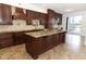 The kitchen features rich wood cabinetry, stainless steel appliances, granite countertops and a large island at 14126 Fox Glove St, Winter Garden, FL 34787