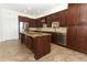 Gourmet kitchen boasting dark wood cabinetry, granite countertops, stainless steel appliances, and tiled floor at 14126 Fox Glove St, Winter Garden, FL 34787