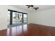 A bright living room with hardwood flooring, ceiling fans, and sliding glass doors overlooking a screened pool at 14126 Fox Glove St, Winter Garden, FL 34787