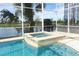 A spa sits next to the enclosed pool, with a view of the lake outside at 14126 Fox Glove St, Winter Garden, FL 34787