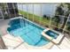 A spa and pool sit within the enclosed pool area, with a view of the lake outside at 14126 Fox Glove St, Winter Garden, FL 34787