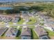 Aerial view of a Primary-planned community featuring houses by a lake, green spaces, and winding streets at 16033 Barkly Ridge Ct, Winter Garden, FL 34787