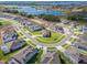 Aerial view of a Primary-planned community featuring houses by a lake, green spaces, and winding streets at 16033 Barkly Ridge Ct, Winter Garden, FL 34787