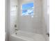 Bright bathroom with white marble tile throughout and window showing blue sky at 16033 Barkly Ridge Ct, Winter Garden, FL 34787