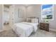 Cozy bedroom with a metal frame bed, a wooden nightstand, and a bright window overlooking the neighborhood at 16033 Barkly Ridge Ct, Winter Garden, FL 34787