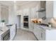Modern kitchen with stainless steel appliances, white cabinets, stone countertops and herringbone floors at 16033 Barkly Ridge Ct, Winter Garden, FL 34787
