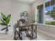 Bright office space featuring a wooden desk, tufted chair, large window and stylish decor, creating an ideal work environment at 16033 Barkly Ridge Ct, Winter Garden, FL 34787