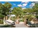 Scenic backyard view featuring a stone patio, wrought-iron railings, and a tranquil lake in the background at 6324 Deacon Cir, Windermere, FL 34786