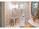 This vintage-style bathroom features floral wallpaper, a pedestal sink, and a decorative mirror with pink, white, and gold finishes at 6324 Deacon Cir, Windermere, FL 34786