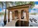 A unique boat house on the water with a private dock and tile roof, columns, and a stone walkway leading to the structure at 6324 Deacon Cir, Windermere, FL 34786