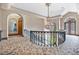 A foyer features a grand chandelier, curved staircase, and arched doorways at 6324 Deacon Cir, Windermere, FL 34786