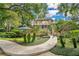 Beautiful home showcasing manicured landscaping, a stone walkway, and a charming gazebo with a blue roof at 6324 Deacon Cir, Windermere, FL 34786