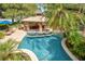 Inviting backyard with a uniquely shaped pool, spa, outdoor kitchen, and comfortable seating area at 6324 Deacon Cir, Windermere, FL 34786