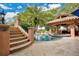 This backyard pool features an outdoor bar with a jacuzzi nearby with stairs leading down from a home with lovely landscaping at 6324 Deacon Cir, Windermere, FL 34786