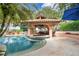 A luxurious pool area includes a covered bar and seating area, surrounded by lush landscaping and clear blue water at 6324 Deacon Cir, Windermere, FL 34786