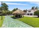 Backyard featuring a shuffleboard court, tiki hut, and a partial view of the house at 1965 Lake Markham Preserve Trl, Sanford, FL 32771