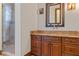 Bathroom featuring granite counters, wood cabinets, square mirror, and glass-enclosed shower with tile surround at 1965 Lake Markham Preserve Trl, Sanford, FL 32771